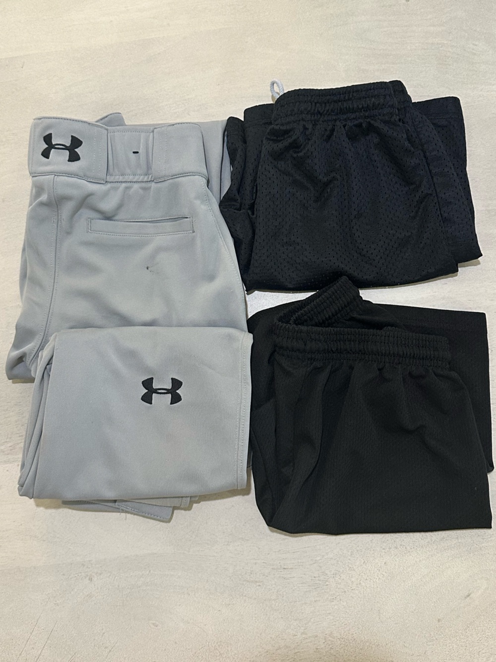 Under Armour.  TWO pairs Light Gray Ball Pants & TWO pairs off-brand shorts.